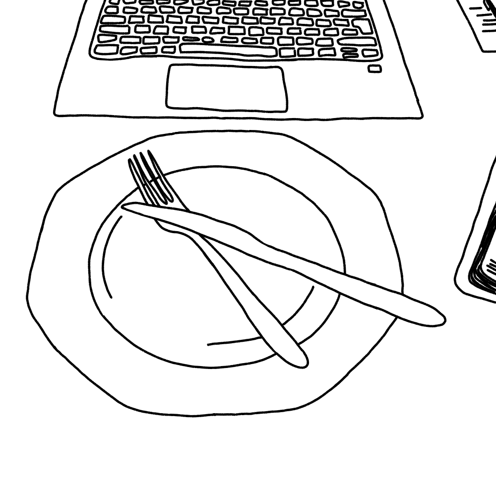 Ein Laptop steht auf einem Schreibtisch. Ein Teller davor.