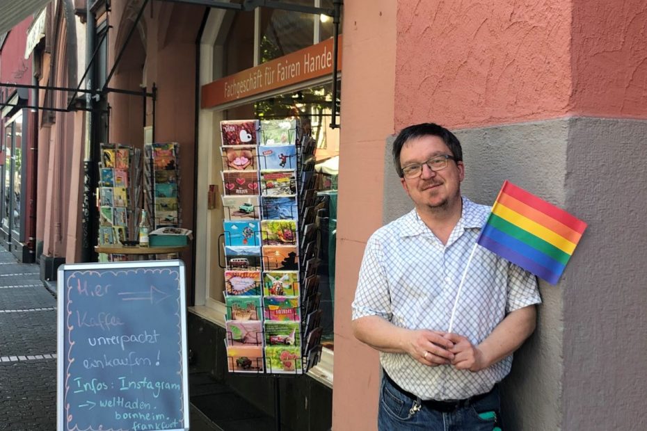 Stefan Diefenbach mit Regenbogenfahne in der Hand - vor dem Weltladen in Frankfurt